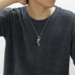 Detail shot of a men's vintage silver swordfish pendant necklace on a knit sweater