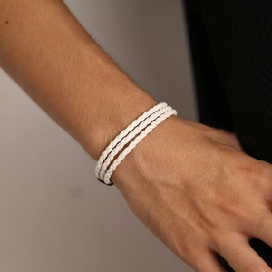 Close-up of triple-layered white braided leather bracelet on wrist with fine textures