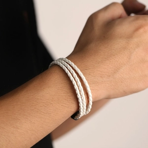 Men's multi-layer white braided leather bracelet with black metal clasp on male wrist