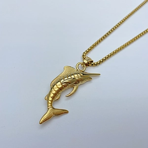 Detailed close-up of a golden marlin fish pendant with a robust stainless steel box chain