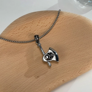 Detailopname van een punk stalen halsketting met bijl-hanger en gedetailleerd schedelontwerp