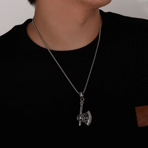 Detailopname van een punk bijlhanger voor heren met schedel aan een vintage stalen ketting