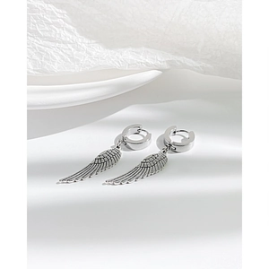 Detail view of silver punk angel wing earring with retro texture and polished steel hoop