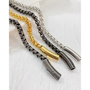 Makroansicht von Edelstahl-Boxketten-Armbändern in Silber, Gold und Schwarz für Herren
