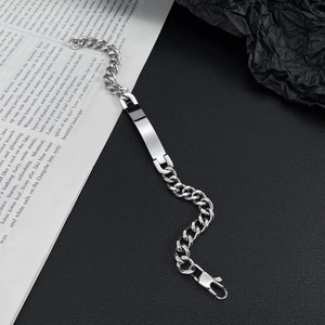 Polished stainless steel Cuban link ID bracelet with secure lobster clasp on vintage background