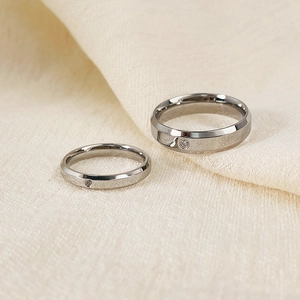Close-up of minimalist silver titanium steel couple rings with small inlaid diamonds
