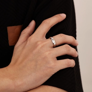 Macro shot of faceted stainless steel ring featuring a single inset round diamond accent