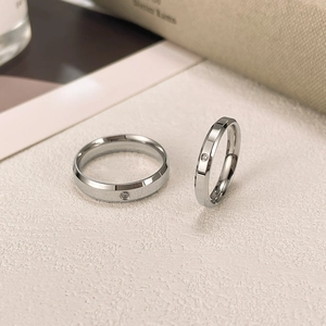 Detailed view of silver titanium steel couple rings with minimalist diamond inlay