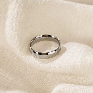 Macro shot of minimalist silver stainless steel ring on soft fabric background