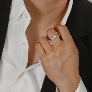 Close-up of men's minimalist silver stainless steel ring with a single small diamond