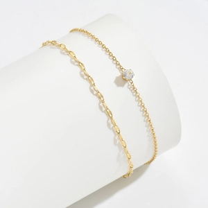 Bracelet de cheville double couche doré avec pendentif en zircone sur socle blanc