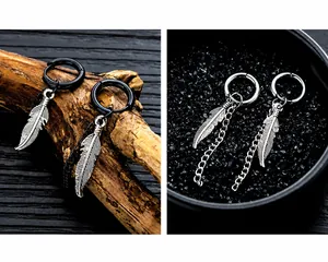 Detalle de pendientes de aro de acero inoxidable con colgantes de plumas y cadenas