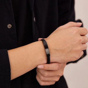 Primer plano de pulsera trenzada de cuero negro para hombre con placa de metal mate