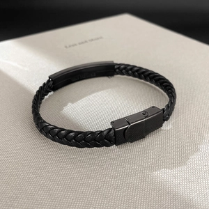 Primer plano de pulsera de cuero trenzado negro con cierre de acero inoxidable mate