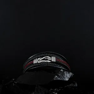 Macro detail of men's braided leather bracelet with red stitching and steel twist clasp