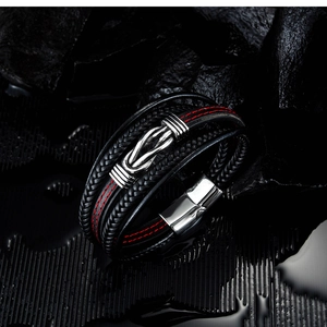 Detail of layered leather bracelet featuring black braided ropes and magnetic clasp