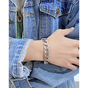 Nahaufnahme eines klobigen silbernen Gliederkettenarmbands aus Edelstahl am Handgelenk