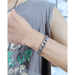 Nahaufnahme eines polierten silbernen Edelstahl-Panzerarmbands am männlichen Handgelenk