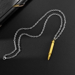 Détail d'un pendentif balle doré sur une chaîne en acier argenté sur fond en cuir noir