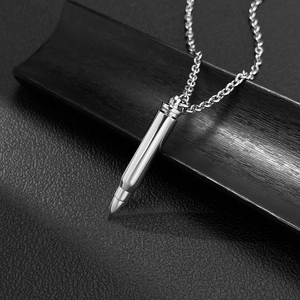 Détail du pendentif balle poli avec une chaîne en métal sur une surface en cuir noir