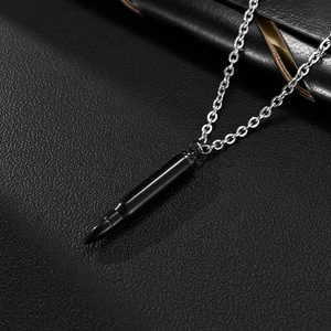 Détail d'un pendentif balle noire avec chaîne argentée sur cuir noir élégant