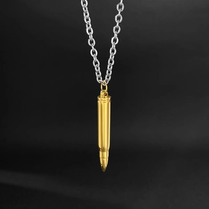 Pendentif balle dorée polie avec chaîne en acier inoxydable sur fond noir brillant