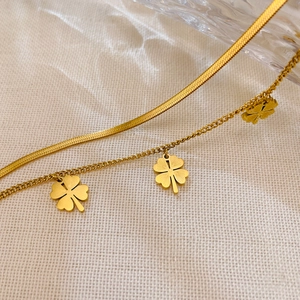 Detail der zweilagigen goldenen Fußkette mit Kleeblatt-Anhängern an Schlangen- und O-Kette