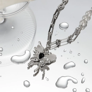 Detail der Schmetterlingskette mit schwarzem Stein, Perlenstrang und Stahlgliederette