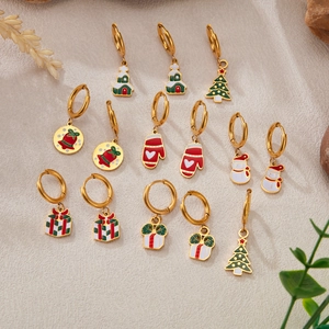 Vue détaillée du lot de boucles d'oreilles de Noël dorées avec sapin, cloche et gants