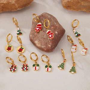 Détail de boucles d'oreilles de Noël avec motifs en émail festif sur un support en pierre
