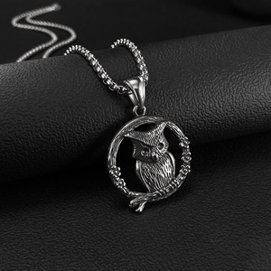 Detailopname van vintage titaanstaal uil hanger met verfijnde details aan een kralenketting