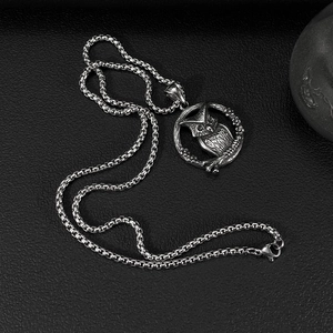 Retro roestvrijstalen uil hanger ketting met box chain op zwarte lederen achtergrond