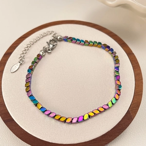 Detail van iriserende kralenarmband met roestvrijstalen sluiting en verlengketting