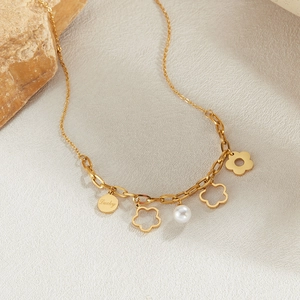 Dettaglio della collana in acciaio dorato con ciondolo Lucky, fiori e perla bianca