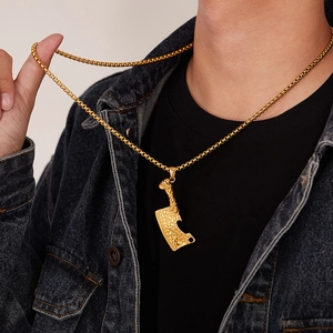 Détail d'un collier punk hachoir doré pour homme avec texture martelée sur veste denim
