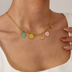 Goldene Edelstahlhalskette mit bunten Emaille-Schmetterlingsanhängern an einem Model