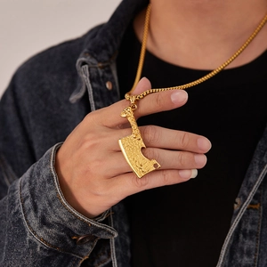 Détail d'un pendentif couteau de chef doré avec texture martelée sur une chaîne box