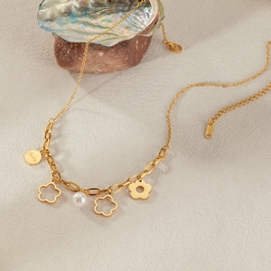 Collana in acciaio inossidabile dorato con ciondoli a fiore traforati e dettaglio perla