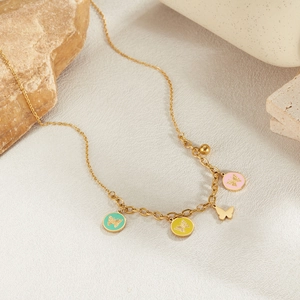 Edelstahl Halskette in Gold mit bunten Emaille-Schmetterlingen auf Natursteinhintergrund