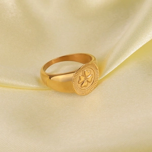 Gold plated stainless steel signet ring with embossed four leaf clover and radial sunburst