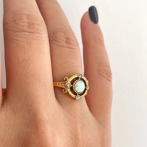 Anillo vintage bañado en oro 18K con ópalo blanco en mano femenina
