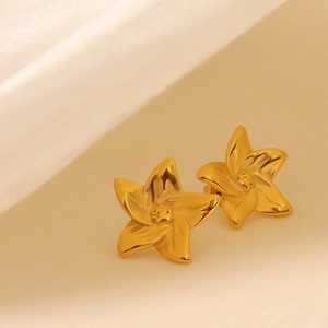 Minimalist gold-plated five-petal flower stud earring on elegant textured fabric