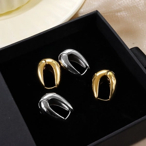 Boucles d'oreilles en acier titane en forme de U or et argent sur présentoir en velours