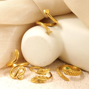 Set de 4 anillos dorados de acero inoxidable con diseños de serpiente, pluma y corazón