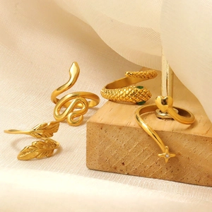 Conjunto de anillos dorados de serpiente y corazón en seda y soporte de madera