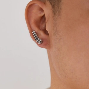 Detail van de retro punk oormanchet met zilveren doodskoppen in gothic hiphopstijl