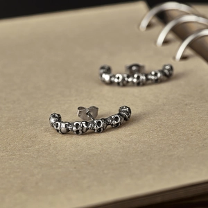 Détail macro de boucles d'oreilles tête de mort vintage sur fond de carnet