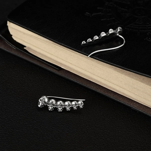 Detail van gothic schedel oorringen met vintage afwerking op donker lederen oppervlak