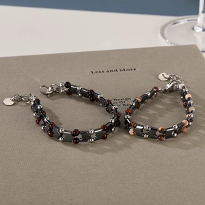 Dettaglio di bracciale vintage con perline di pietra zebra e chiusura a moschettone in acciaio