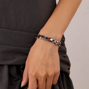 Dettaglio del bracciale con pietre occhio di tigre e zebra indossato con frecce di ematite